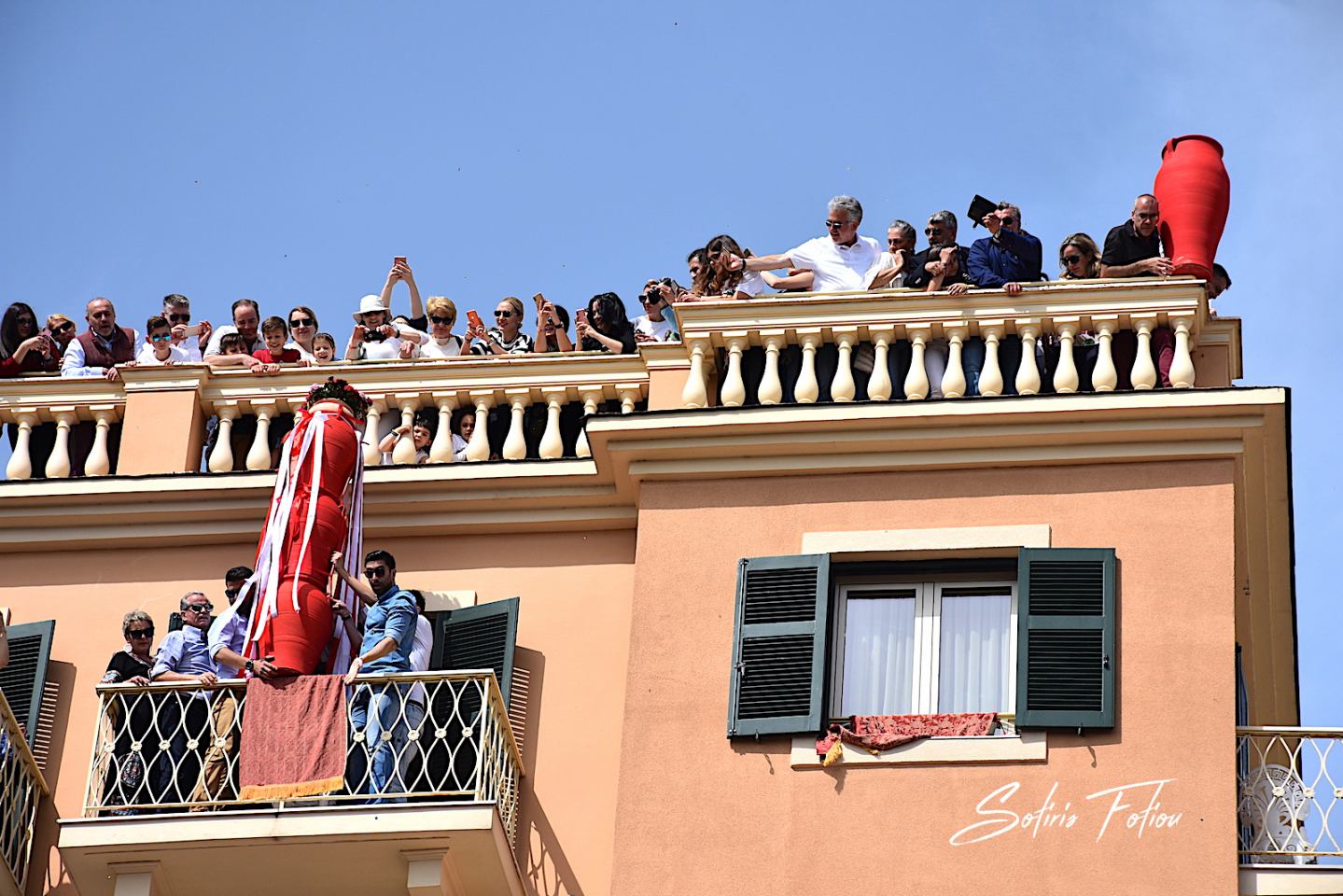 Locals preparing to throw clay pots from a rooftop in Corfu Old Town during the Botides tradition